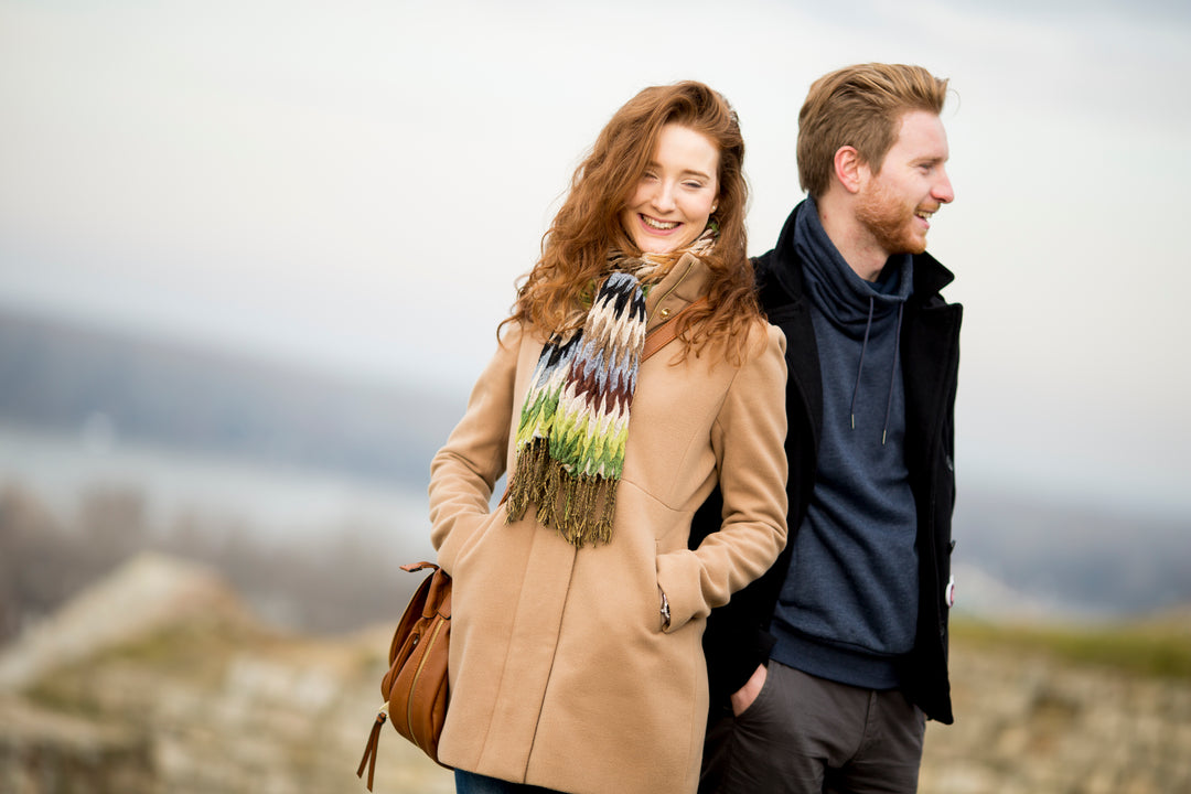 Man and woman standing outdoors with a scenic background
